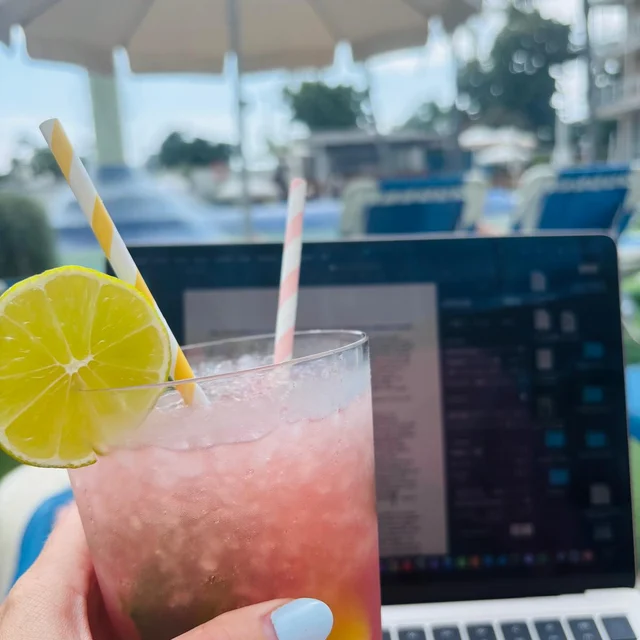 Roze drankje met limoen voor een opengeklapte laptop